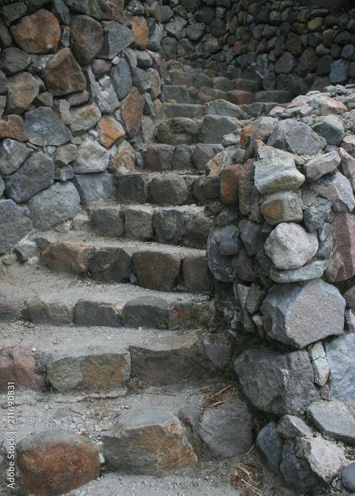 Fototapeta Kamienne schody wijące się w górę przez kamienne ściany
