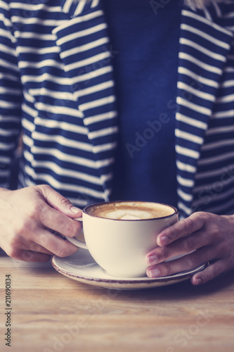 Girl having a break with cup of coffee, close up, soft focus, vintage filter.