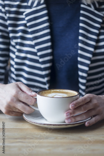 Girl having a break with cup of coffee, close up, soft focus, vintage filter.