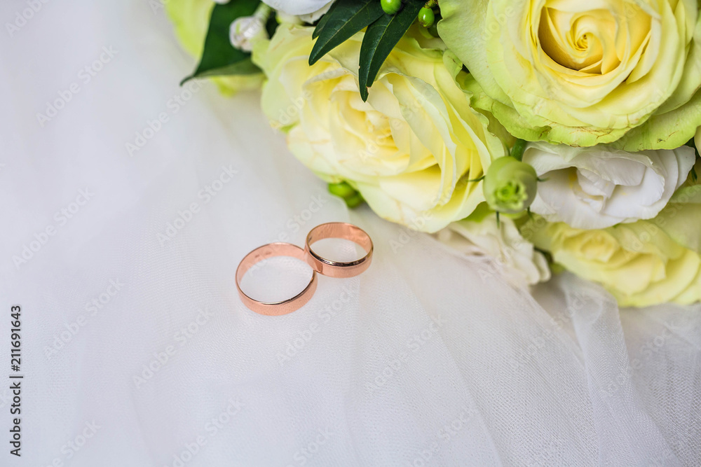 Couple of wedding rings near rosebuds, closeup Couple of wedding rings near rosebuds, closeup