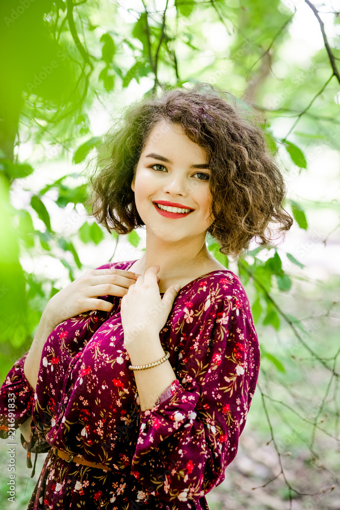 Cute girl with curly hair poses in the park Cute girl with curly hair poses in the park
