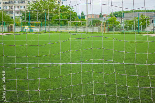 synthetic football green field space with nobody and foreshortening behind  goal