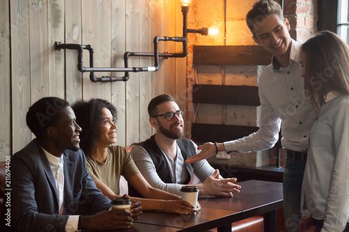 Картината върху платно Smiling Caucasian boyfriend introducing multiracial friends to girlfriend at meeting in coffeeshop, millennial male acquainting diverse colleagues with female worker in cafe