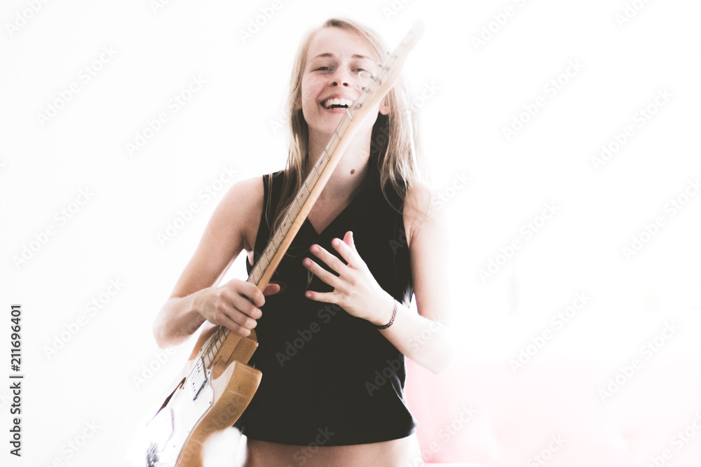 beautiful young woman playing electric guitar and making music beautiful young woman playing electric guitar and making music