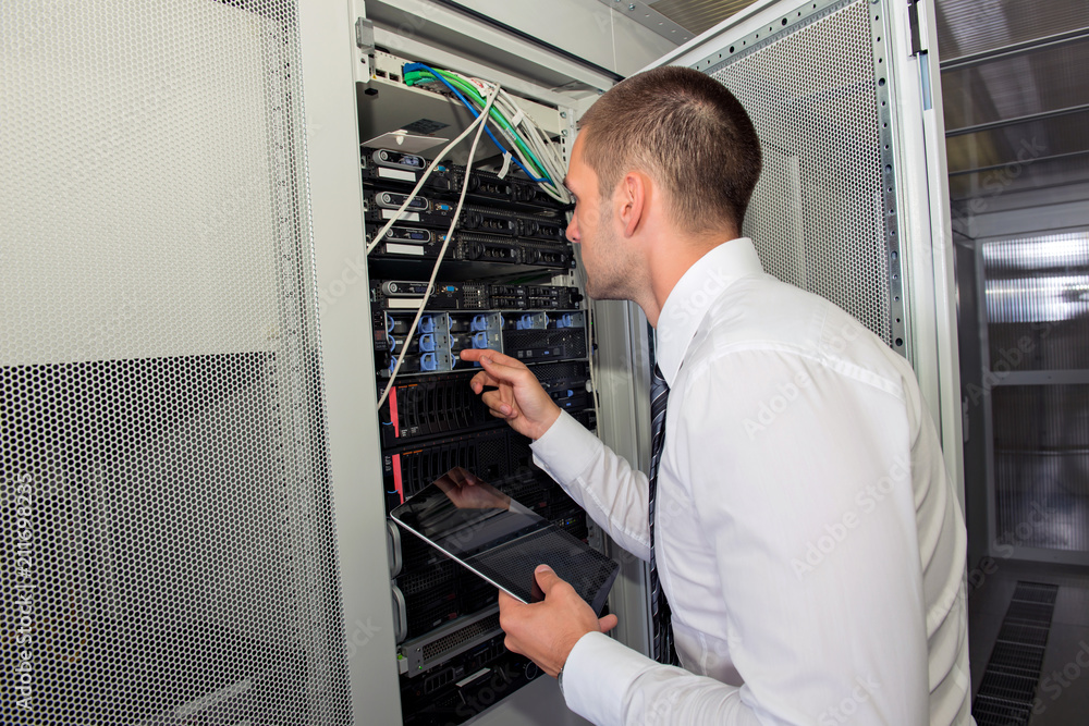 Fototapeta premium Young handsome business man engeneer in datacenter server room