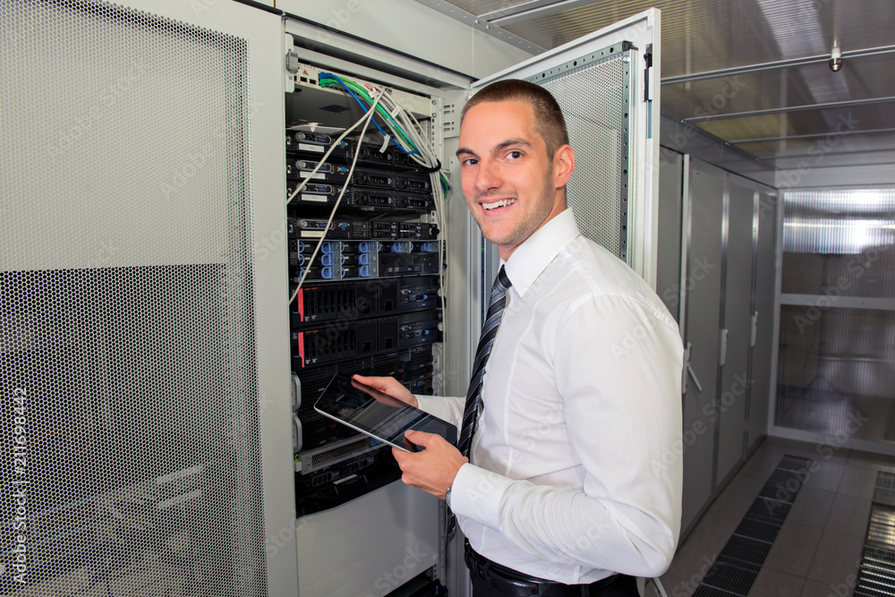 Fototapeta premium Young handsome business man engeneer in datacenter server room