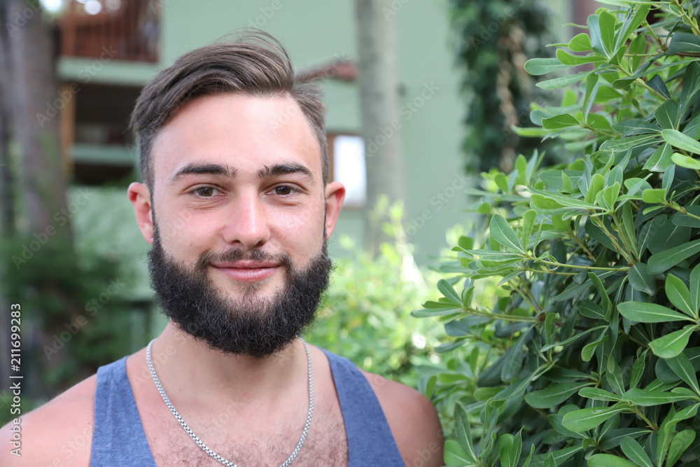 Young man with black hair and beard in the Park in a summer evening Young man with black hair and beard in the Park in a summer evening