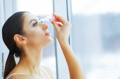 Health and Beauty. Eye Care. Beautiful Young Woman Holding Drops For Eyes. Good Vision. Happy Girl with Fresh Look. photo