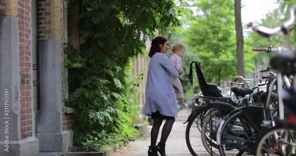 Mother lifting child into bicycle seat Mother lifting child into bicycle seat