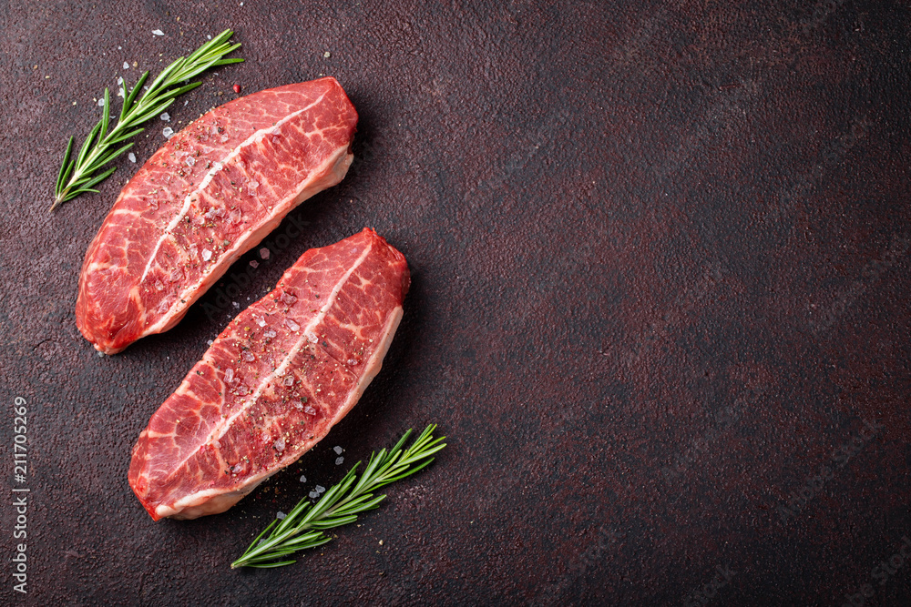 Raw fresh meat Top Blade steaks on dark background. top view with copy space