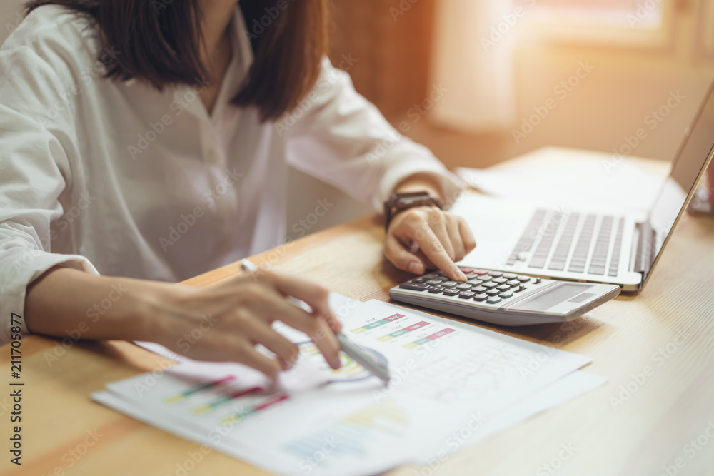Fototapeta premium Businesswoman in office and use computer and calculator to perform financial accounting. To plan advance budget.