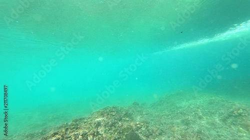 Underwater view of wave breaking over coral reef with spinning vortex photo