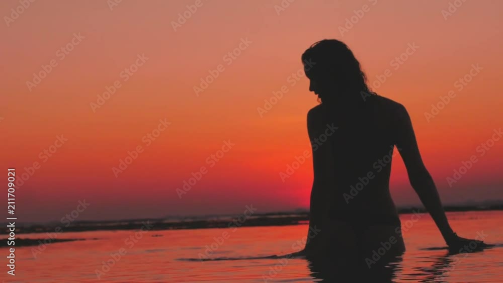 Pretty girl having the pleasure in water of tropical sea after sunset Pretty girl having the pleasure in water of tropical sea after sunset