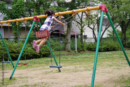 公園のブランコで遊ぶ女の子