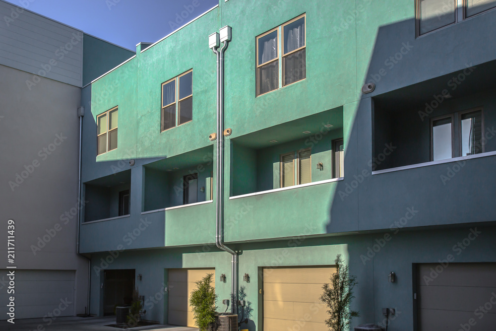 Garages and balconies on teal townhouses