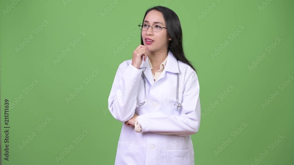 Young beautiful Asian woman doctor thinking Young beautiful Asian woman doctor thinking