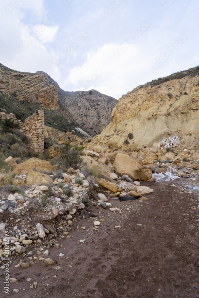 Beautiful landscape of dried salty mountain river with clouds in the sky at La Rambla, La Murada, Orihuela, Spain Mountain area with small river extremely dry and salty. the water created a unique Beautiful landscape of dried salty mountain river with clouds in the sky at La Rambla, La Murada, Orihuela, Spain Mountain area with small river extremely dry and salty. the water created a unique