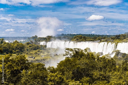 Wide angle landscape view of Iguazu falls waterfalls on a sunny day in summer. Photo taken from the Argentinian side.