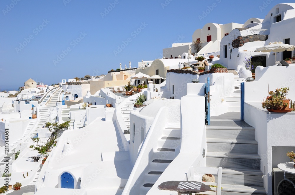 Famous stunning view of white architectures and colorful houses above the volcanic caldera in the village of Oia in Santorini island, Greece