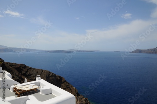 Recliner Chairs for love couples toward Famous stunning view of aegean sea above the volcanic caldera in the village of Oia in Santorini island, Greece