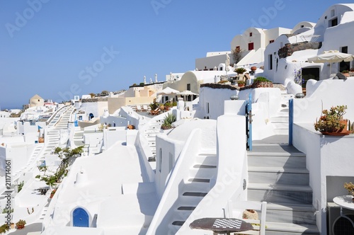 Famous stunning view of white architectures and colorful houses above the volcanic caldera in the village of Oia in Santorini island, Greece