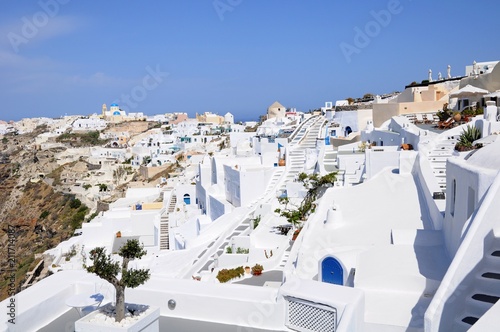 Famous stunning view of white architectures and colorful houses above the volcanic caldera in the village of Oia in Santorini island, Greece
