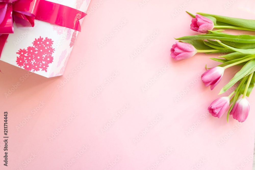 gift with pink ribbon and pink tulips on pink background gift with pink ribbon and pink tulips on pink background
