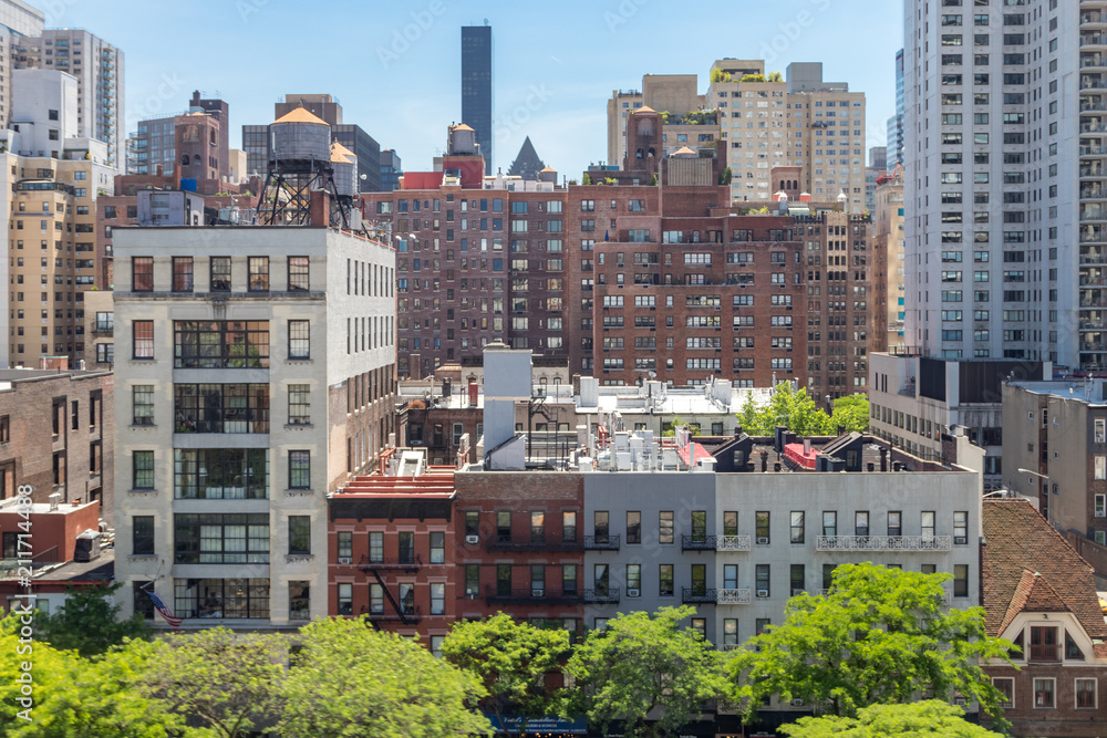 Naklejka premium Miasto Nowy Jork - Zasięrzutny widok historyczni budynki wzdłuż 59th ulicy z środek miasta Manhattan linią horyzontu w tle
