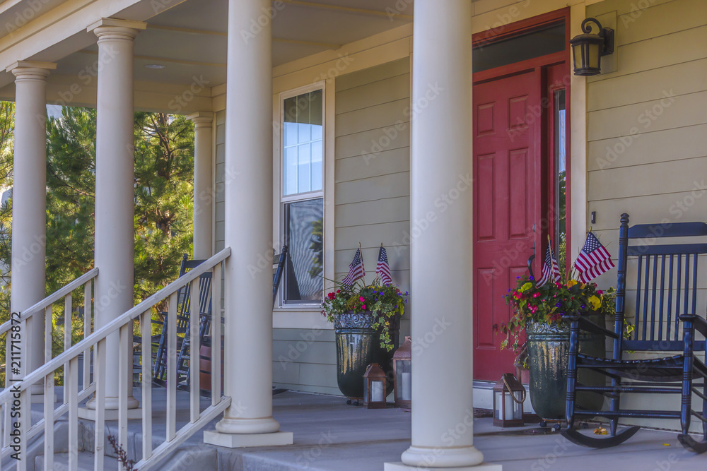Red front door with seating area and white pillars Red front door with seating area and white pillars