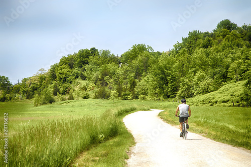 Cyclist on the beautiful meadow trail on sunny day © Anjelika Gretskaia