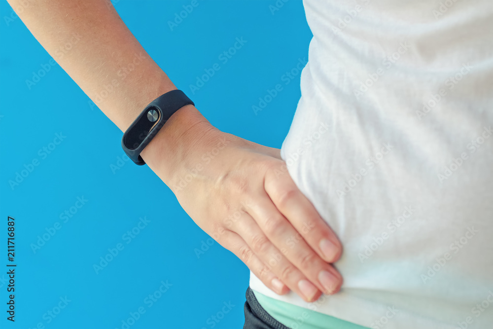young woman with fitness tracker on hand on blue background young woman with fitness tracker on hand on blue background
