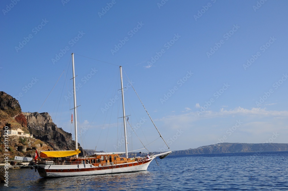 The sailing ships on Aegean sea near the port of Thira in Santorini island, Greece
