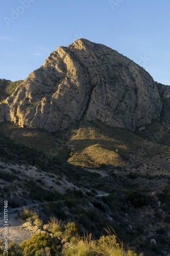 Mountain pico del agudo La Murada Orihuela, Spain Mountain landscape with path. Hiking and healthy life.natural landscape of the Spanish Levante with vgetation and arid land sunrise light in spring