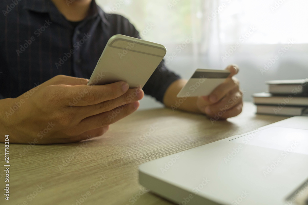 Fototapeta premium Man holding credit card and using smartphone for payment shopping online.