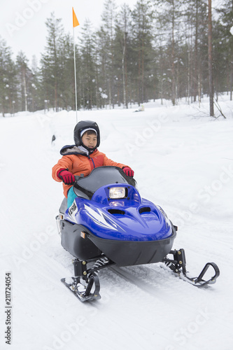 スノーモービルに乗る子供 雪景色