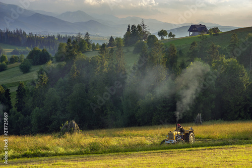 Fototapeta Naklejka Na Ścianę i Meble -  haymaking in the mountains, tractors with mowers cutting the meadows in the Polish mountains
