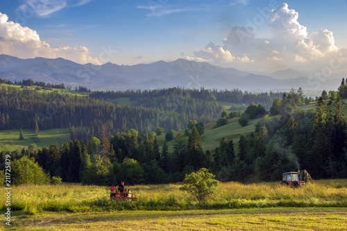 haymaking in the mountains, tractors with mowers cutting the meadows in the Polish mountains
