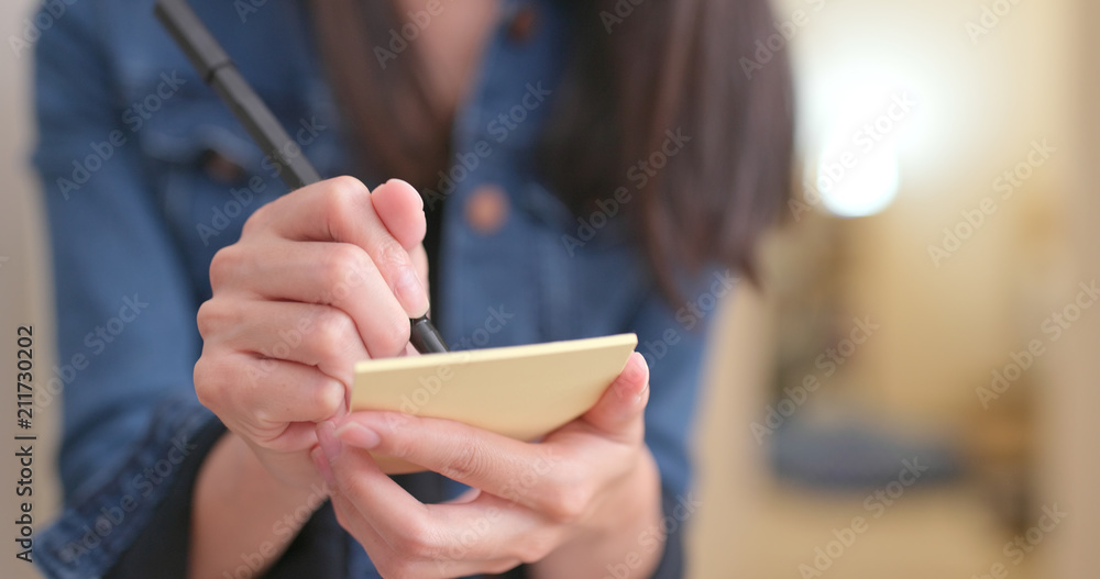Woman jotting note Woman jotting note