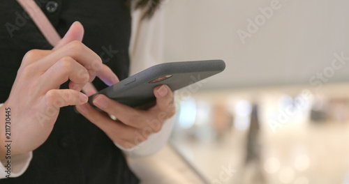 Woman send sms on cellphone in mall