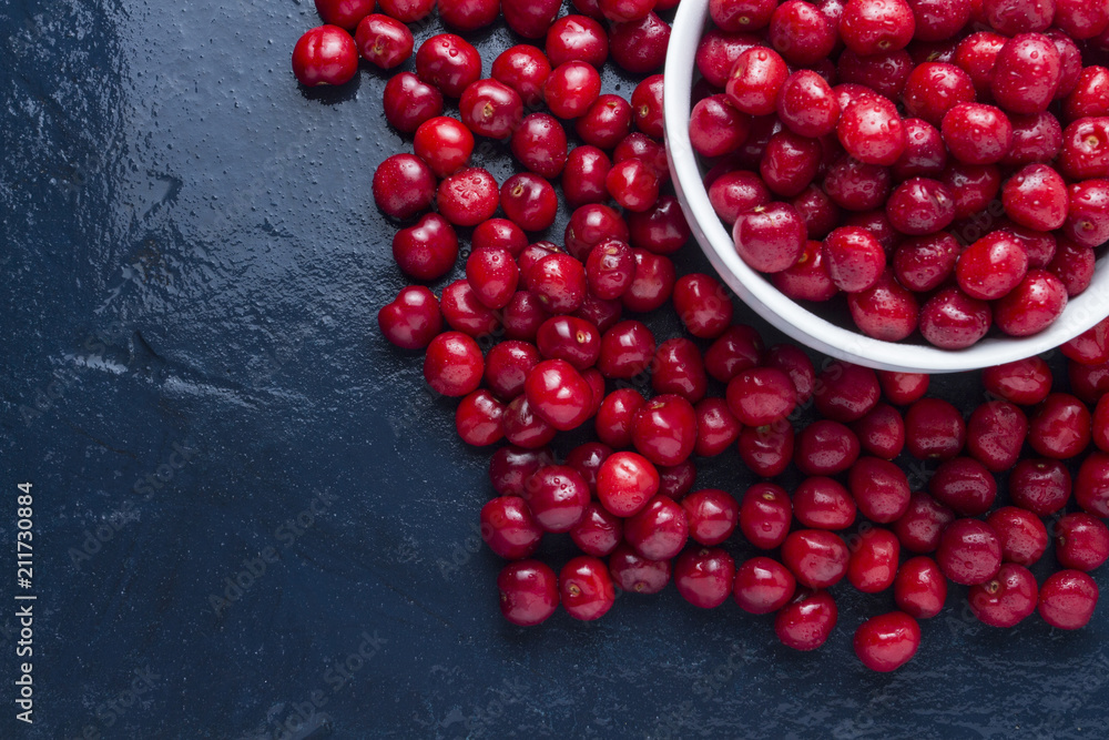 Freshly picked cherry with drops of dew and water in a white bowl. Concept of harvest. Flat lay, top view Freshly picked cherry with drops of dew and water in a white bowl. Concept of harvest. Flat lay, top view