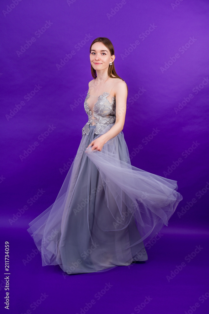 young and beautiful woman bride with makeup in long chic dress dancing ballroom waltz dance in studio on a purple background young and beautiful woman bride with makeup in long chic dress dancing ballroom waltz dance in studio on a purple background
