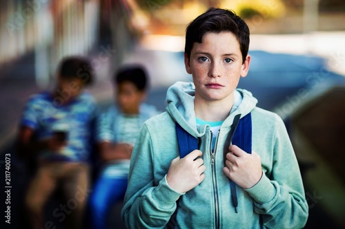 Photography Portrait of sad schoolboy with schoolbag standing in campus