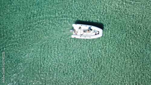Aerial photo of small inflatable speed boat in turquoise clear tropical waters
