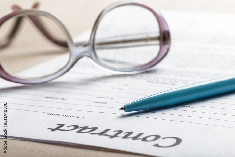 Close up shot of Eyeglasses on contract document papers business concept Close up shot of Eyeglasses on contract document papers business concept