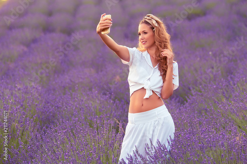 Fototapeta Naklejka Na Ścianę i Meble -  Beautiful woman take a photo in the lavender field