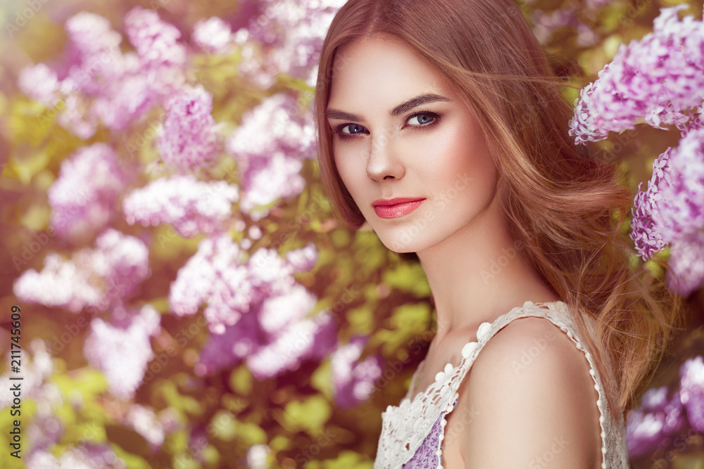 Fototapeta premium Beautiful Woman with Flowers of Lilac. Spring Blossom. Sexy Glamour Summer Beautiful Lady with Healthy and Beauty Hair