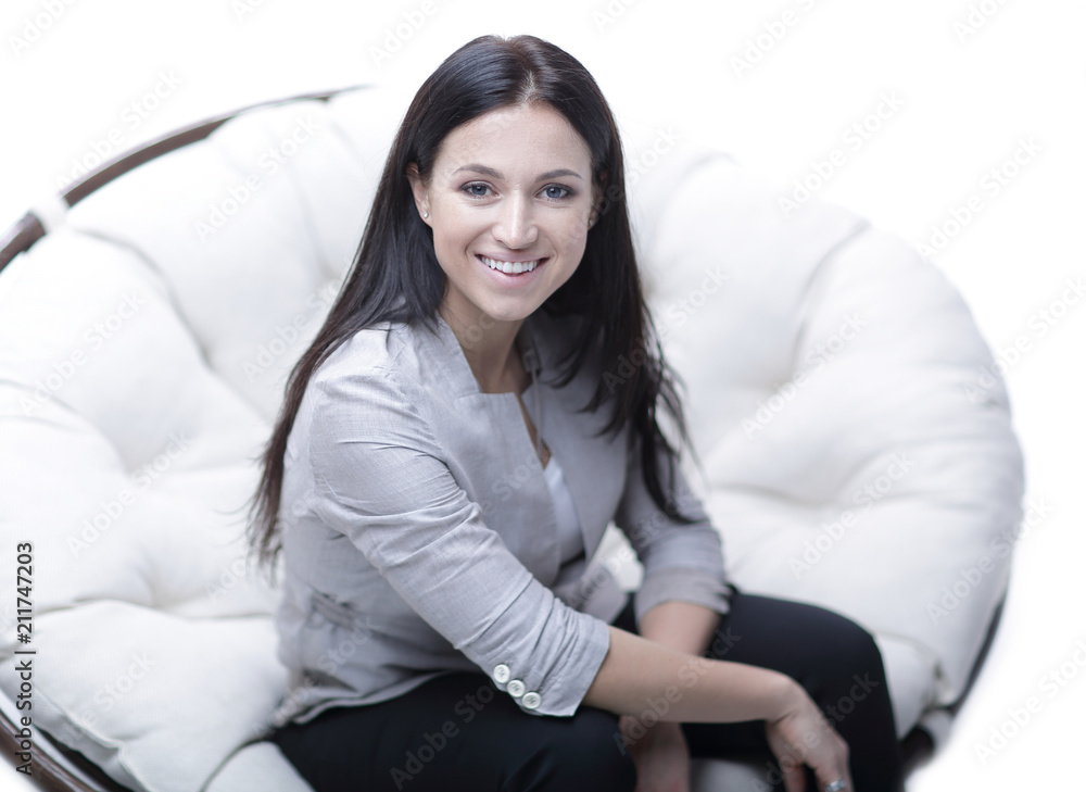 Young woman sitting in a round cozy soft big chair. Young woman sitting in a round cozy soft big chair.