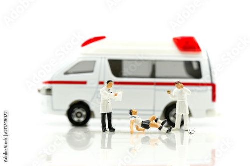 Miniature people : Soccer Football player lying down injured with doctor,Medical aid to the football player concept.