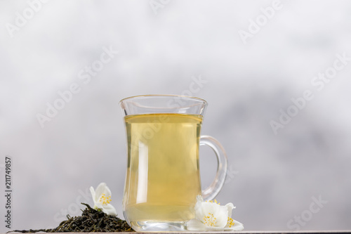 Green tea with jasmine in a glass mug.