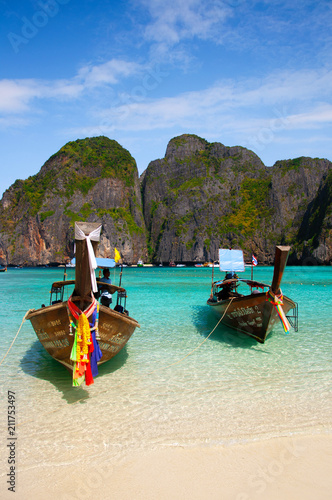 Thai wooden long tail boat on white beach Phi Phi island and turquoise Andaman sea Krabi - Phuket, Thailand